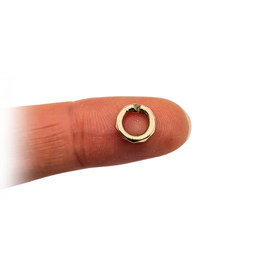Close-up of a chunky 9ct yellow gold faceted jump ring measuring 8mm in diameter and 1.6mm thick. Open ring design tested as 9ct gold, ideal for fine jewellery repair or as a sturdy connector for necklaces and bracelets. Weighs 0.48g.