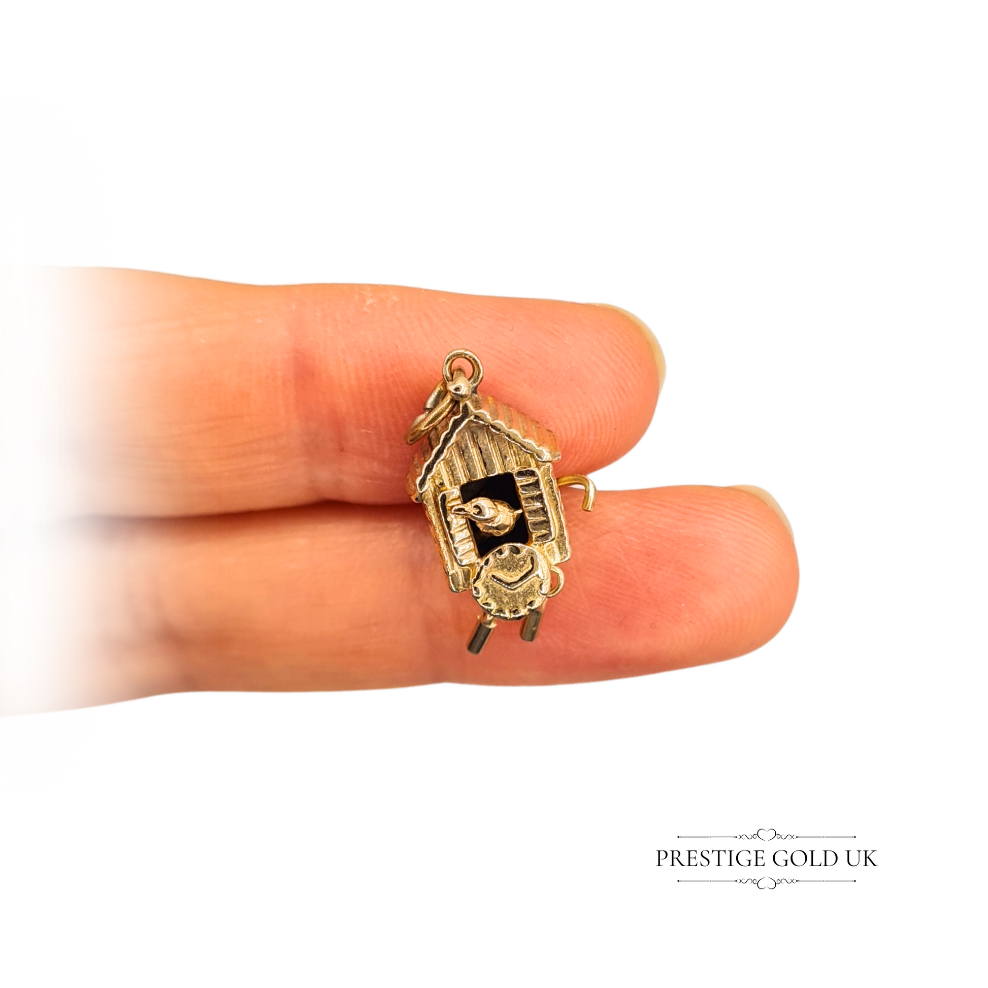 9ct gold cuckoo clock charm featuring a moving bird, measuring 20mm by 10mm, vintage novelty design with intricate details and a very worn hallmark