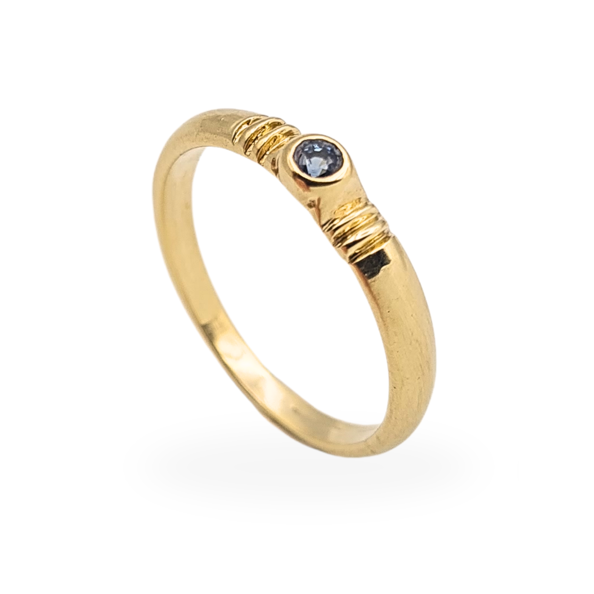 Yellow gold 9ct ring with a single round blue sapphire in a smooth bezel setting, slim 3.2mm band with ridged shoulder detailing, stamped 375 and fully tested, shown on mandrel for scale with close-up views of the stone and setting