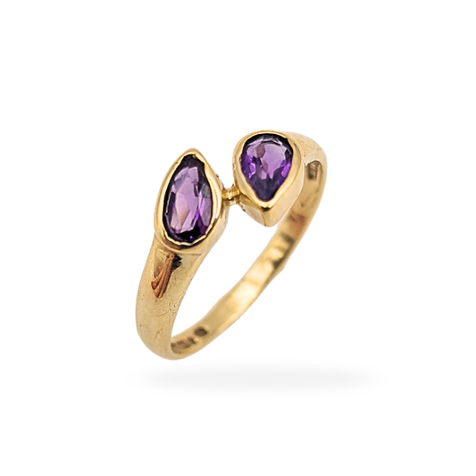9ct gold amethyst twist ring with overlapping bezel set teardrop stones, fully hallmarked Sheffield 1991 with 375 stamp, UK size F US 3, lightweight 1.1g design with rich purple gemstones and smooth polished gold finish.
