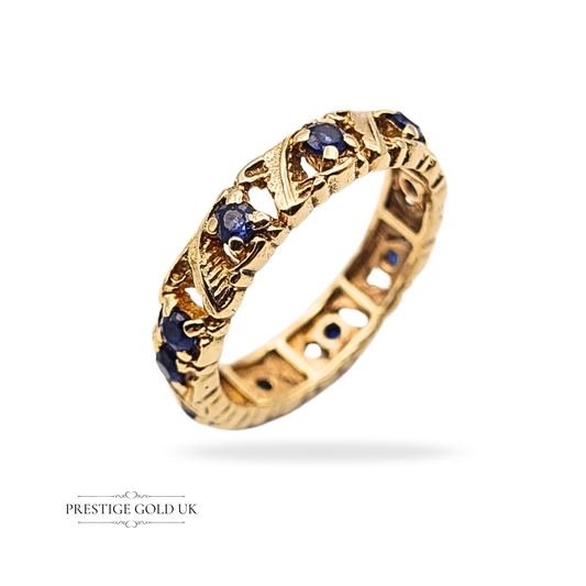9ct gold sapphire full eternity ring, ornate openwork band with continuous deep blue sapphires, 4.2mm wide, weighing 2.6g, UK size K, US size 5 1/4, tested as 9ct gold, vintage style fancy eternity ring with decorative detail.