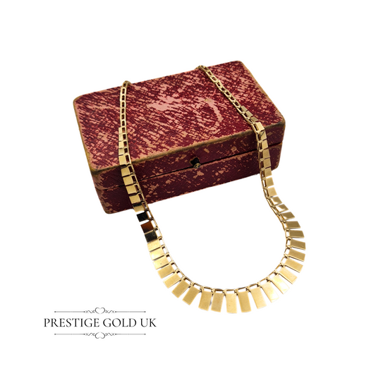 A close-up of a 9ct yellow gold colorette necklace with a ruler measuring the delicate graduated design from 2mm to 8mm deep.