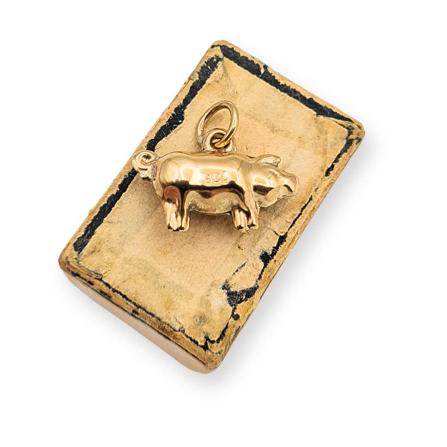 Small 9ct gold puffy pig charm pendant measuring approximately 16mm long and 11mm tall with curled tail and polished hollow body. Stamped 9ct and fully tested gold, shown beside ruler and on fingertip for scale, a novelty animal charm suitable for bracelet or necklace.