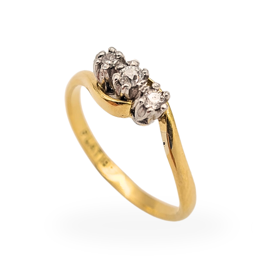 18ct gold crossover ring with three round diamonds set in platinum, stamped Plat 18ct, UK size N, elegant twist band design with raised trilogy setting, classic fine jewellery piece with contrasting yellow gold and white metal settings