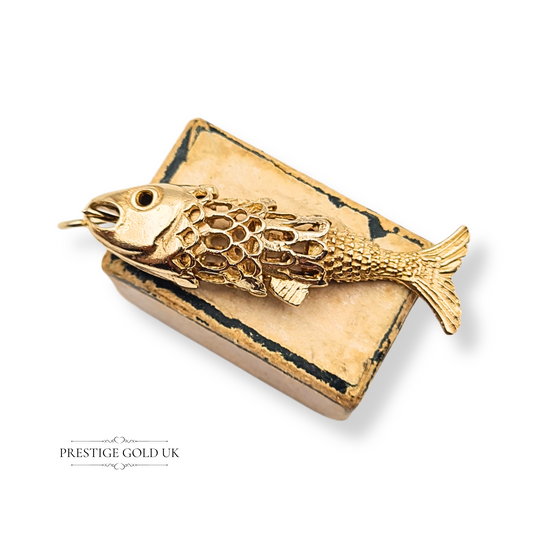 9ct gold articulating fish pendant, hallmarked London 1971, weighing 4.00g, measuring 38mm long by 10mm tall and 7mm deep, hollow design with moving segments, detailed scales and fins, collectible vintage swimming fish charm.