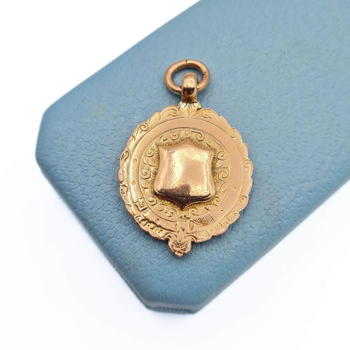 9ct rose gold oval shield fob pendant with ornate engraved decoration, blank central cartouche and Birmingham 1912 hallmarks