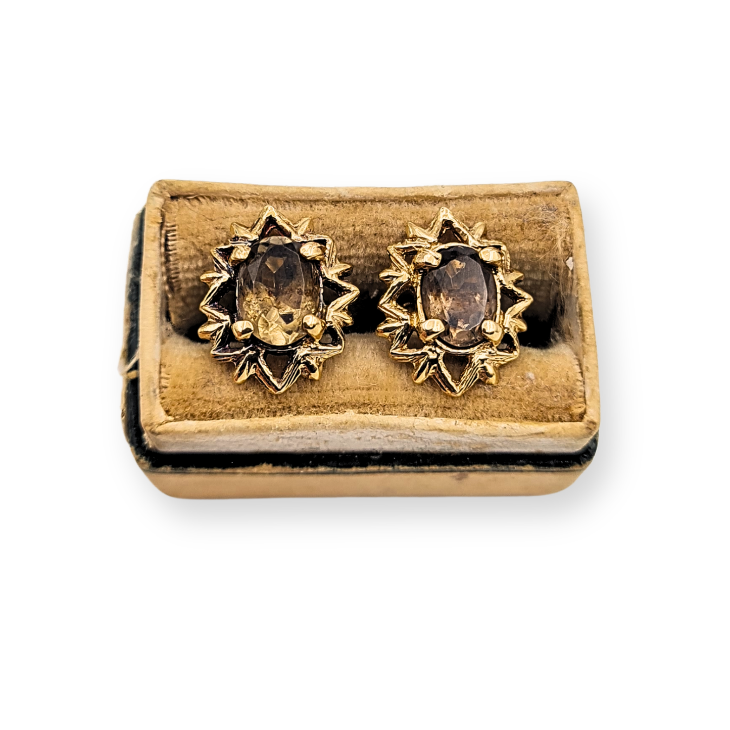 Pair of 9ct yellow gold smoky quartz stud earrings with oval faceted brown gemstones in decorative starburst style claw settings. Fully British hallmarked with post and butterfly backs, measuring approximately 12mm tall by 10mm wide.