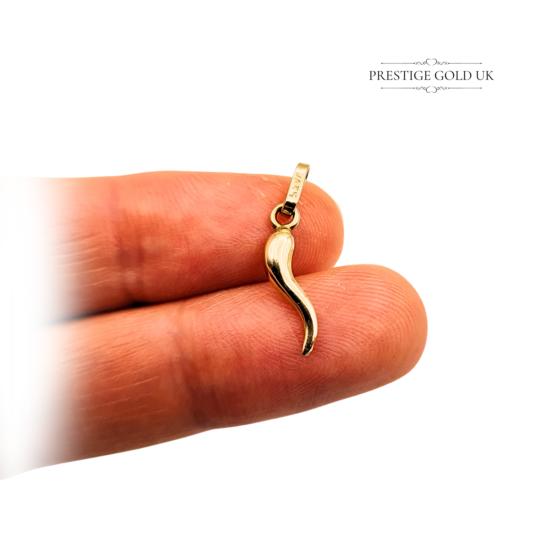 Photograph of a tiny 18ct yellow gold horn of plenty charm, measuring 15mm tall (20mm including bail), hallmarked 750, hollow construction, 0.56g weight, shown on ruler and vintage box by Prestige Gold UK.