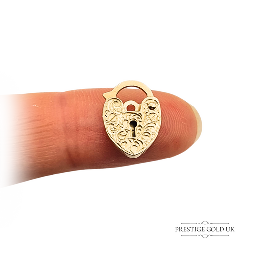 Vintage 9ct gold heart-shaped padlock charm with hand-engraved swirl design, 14mm tall, 1985 hallmark, solid gold with working clasp, ideal for charm bracelets or necklaces.