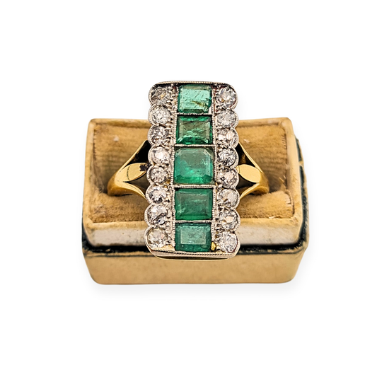 18ct yellow gold dress ring with rectangular emerald and old-cut diamond cluster design. Features five emeralds, one chipped, surrounded by sparkling diamonds. Fully tested 18ct, UK size Q / US 8, weighing 6.5g. Vintage clearance item, 7/10 condition.