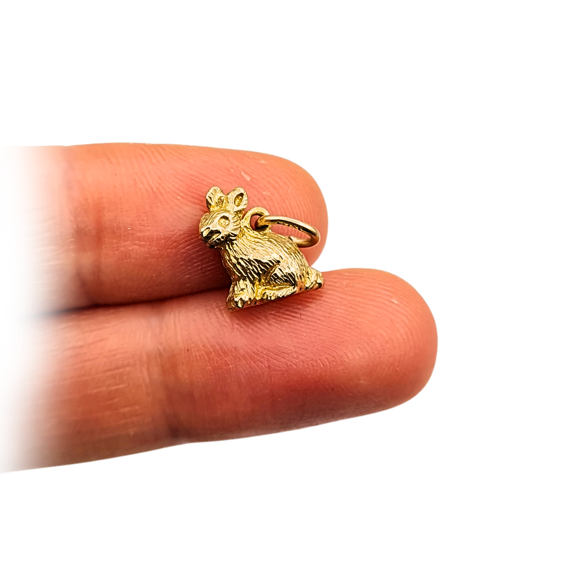 Close-up photo of a tiny 9ct solid gold rabbit charm with fine fur detailing, stamped 9ct on the jump ring. The miniature pendant weighs 1.83g and measures 11mm tall by 9mm wide, shown against a ruler for scale, polished vintage gold finis