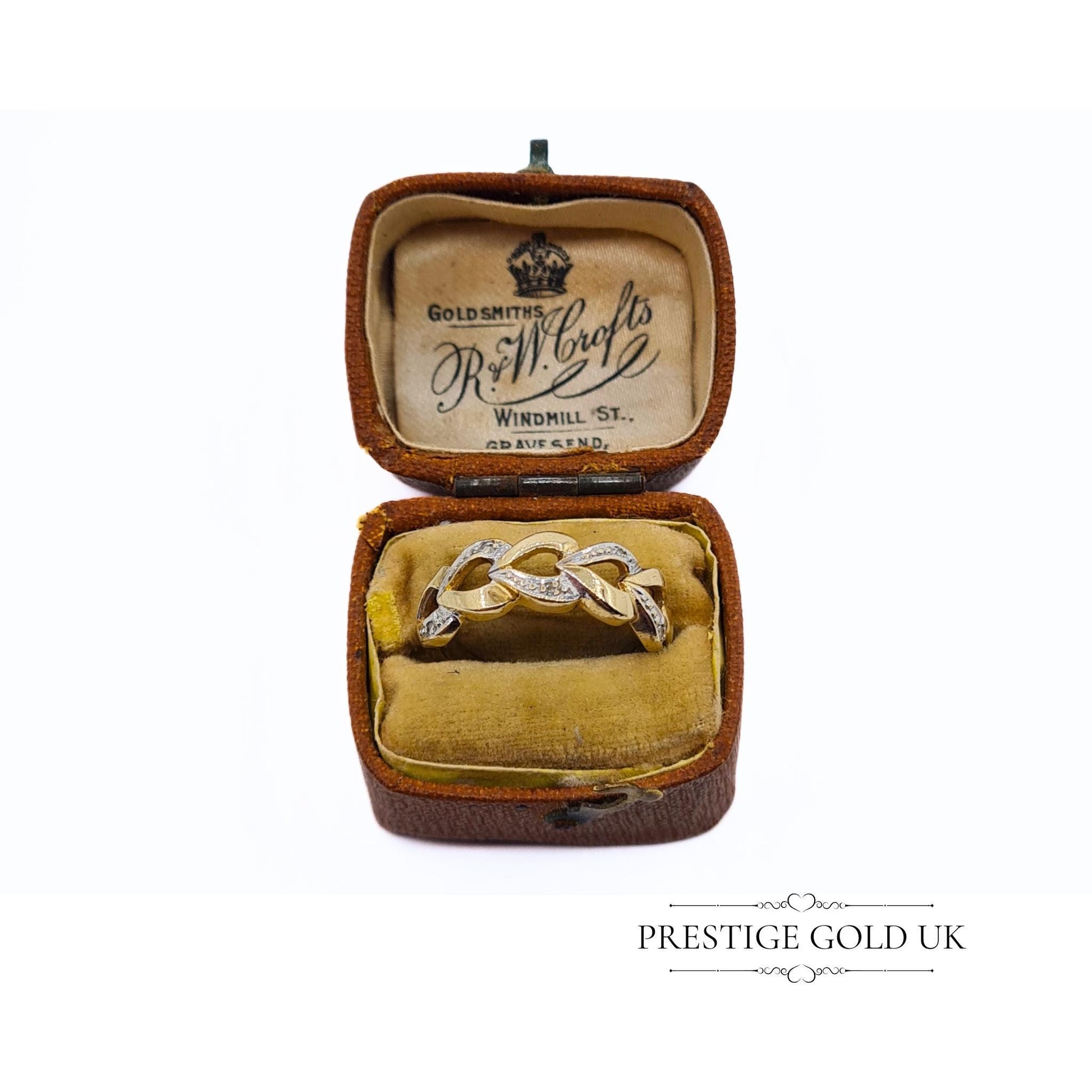 A 1993 British-hallmarked 9ct white and yellow gold ring with interlocking diamond-set hearts and a tapered band, ideal for jewellery lovers and collectors of romantic designs.