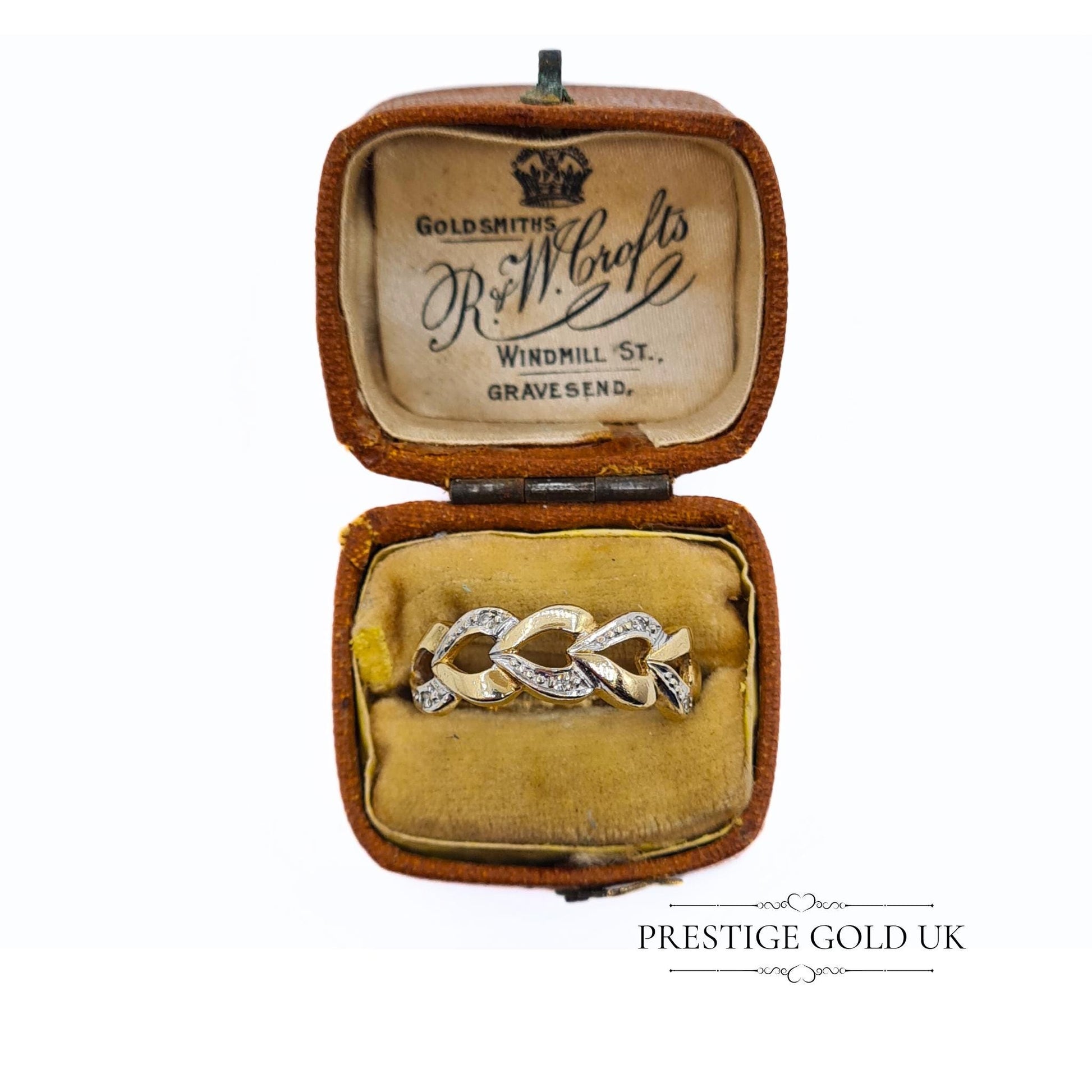 A 1993 British-hallmarked 9ct white and yellow gold ring with interlocking diamond-set hearts and a tapered band, ideal for jewellery lovers and collectors of romantic designs.