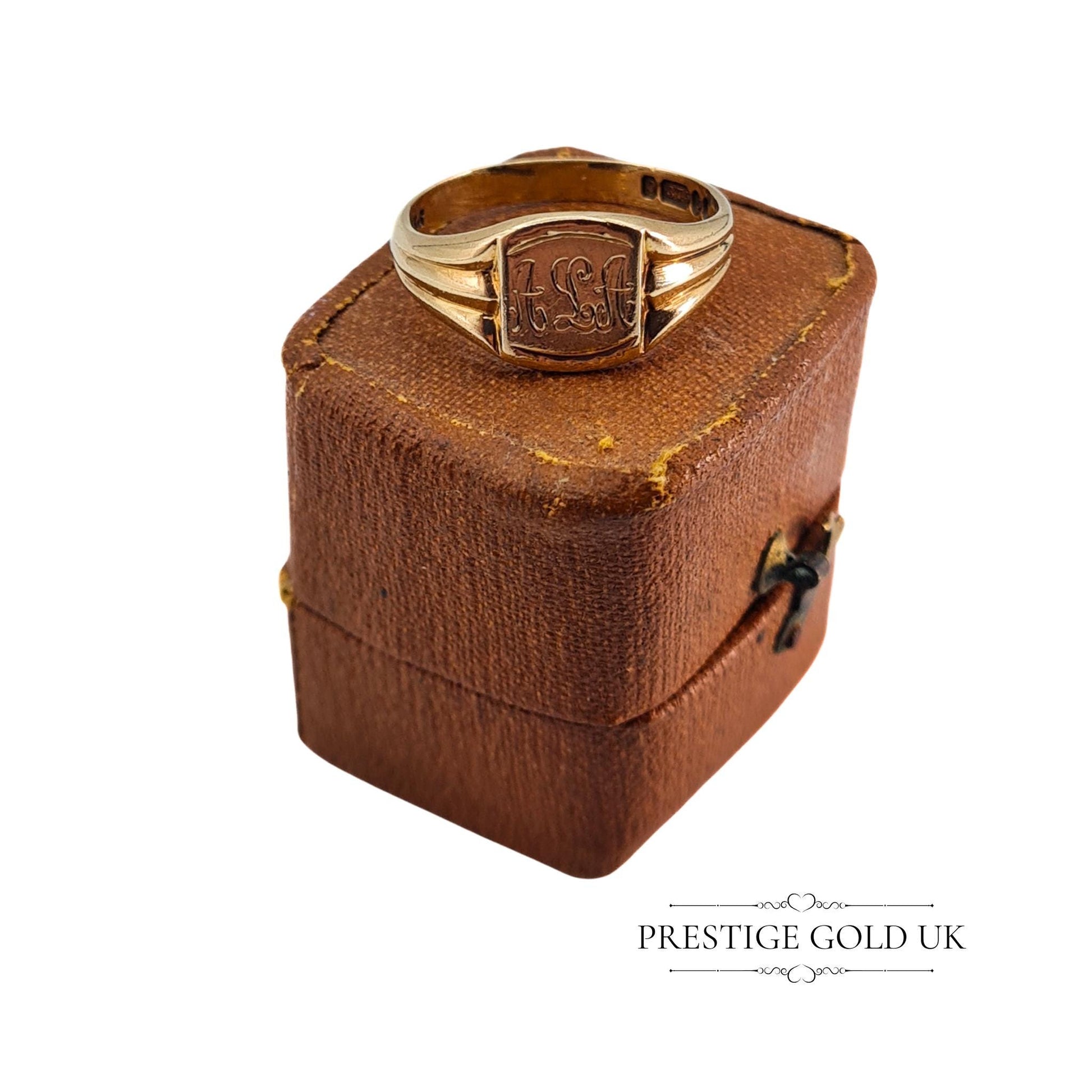 Vintage signet ring displayed in a vintage brown jewellery box, highlighting its unique charm and engraving.